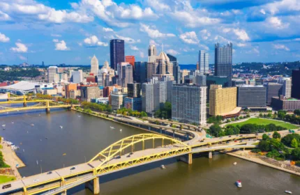 Aerial view of downtown Pittsburgh skyline with yellow bridges crossing the river