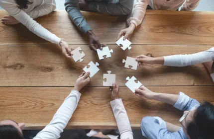 Team collaborating to assemble puzzle pieces, representing contingent workforce supplier management and MSP oversight in 2026