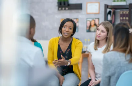 Coworkers sit and discuss a topic, this image reflects that Beacon Hill was featured in a Comparably Listicle on Mental Health Awareness