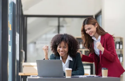 Two professionals reviewing a laptop together in an office, representing collaboration and specialized life sciences staffing support.