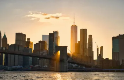 New York City skyline at sunset with One World Trade Center and the Brooklyn Bridge