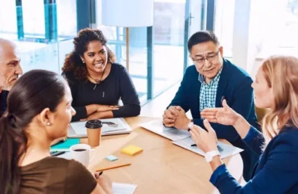 Professionals in a meeting discussing hiring strategy and business growth
