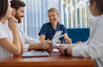 Four professionals collaborate around a conference table.
