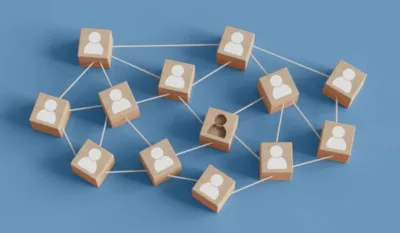 Wooden blocks connected by strings representing team members, with one block showing two figures symbolizing staffing issues and team imbalance.