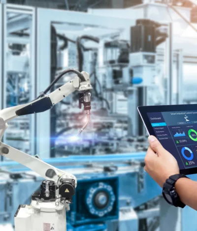Adobe Stock 350888164 Smart industry control concept Hands holding tablet on blurred automation machine