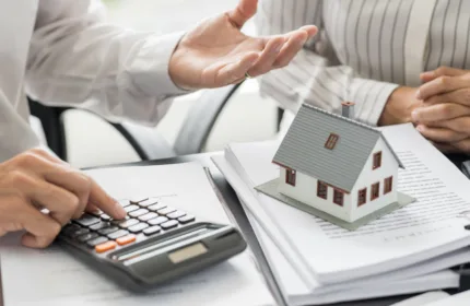 Hands reviewing investment charts and property models, representing admin support for real estate development.