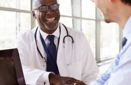 Nurse and patient in a clinical hallway, symbolizing IT systems supporting healthcare operations.