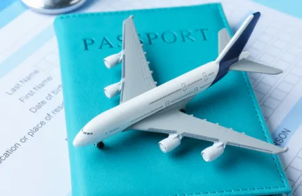 Passport, travel documents, and a miniature airplane symbolizing travel insurance services provided by BH Technologies.