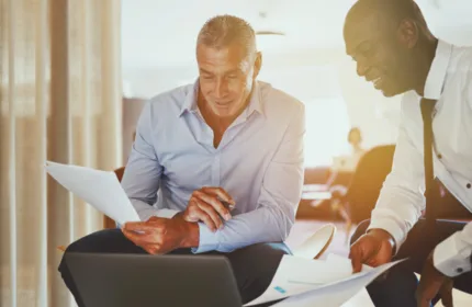 Two professionals reviewing paperwork, representing administrative support in insurance operations.