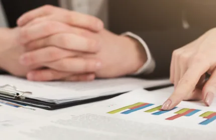 A professional analyzing financial charts, representing administrative and client support in investment banking.