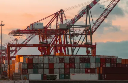 Cargo containers and cranes at a port, representing administrative and operations support in logistics.