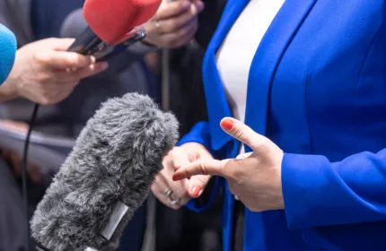 A PR professional speaking to reporters, representing admin and coordination for PR teams.