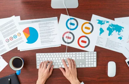 Hands reviewing compliance icons and charts, representing financial compliance and regulatory oversight.