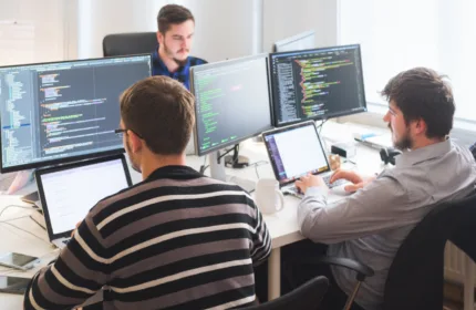 Coworkers meeting at a table, symbolizing IT solutions for software and platform growth.
