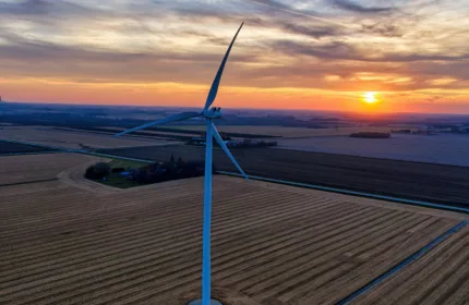 Wind turbines at sunset, representing financial oversight for renewable energy projects.