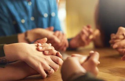 People holding hands in a group, representing organizational support for faith-based and membership associations.