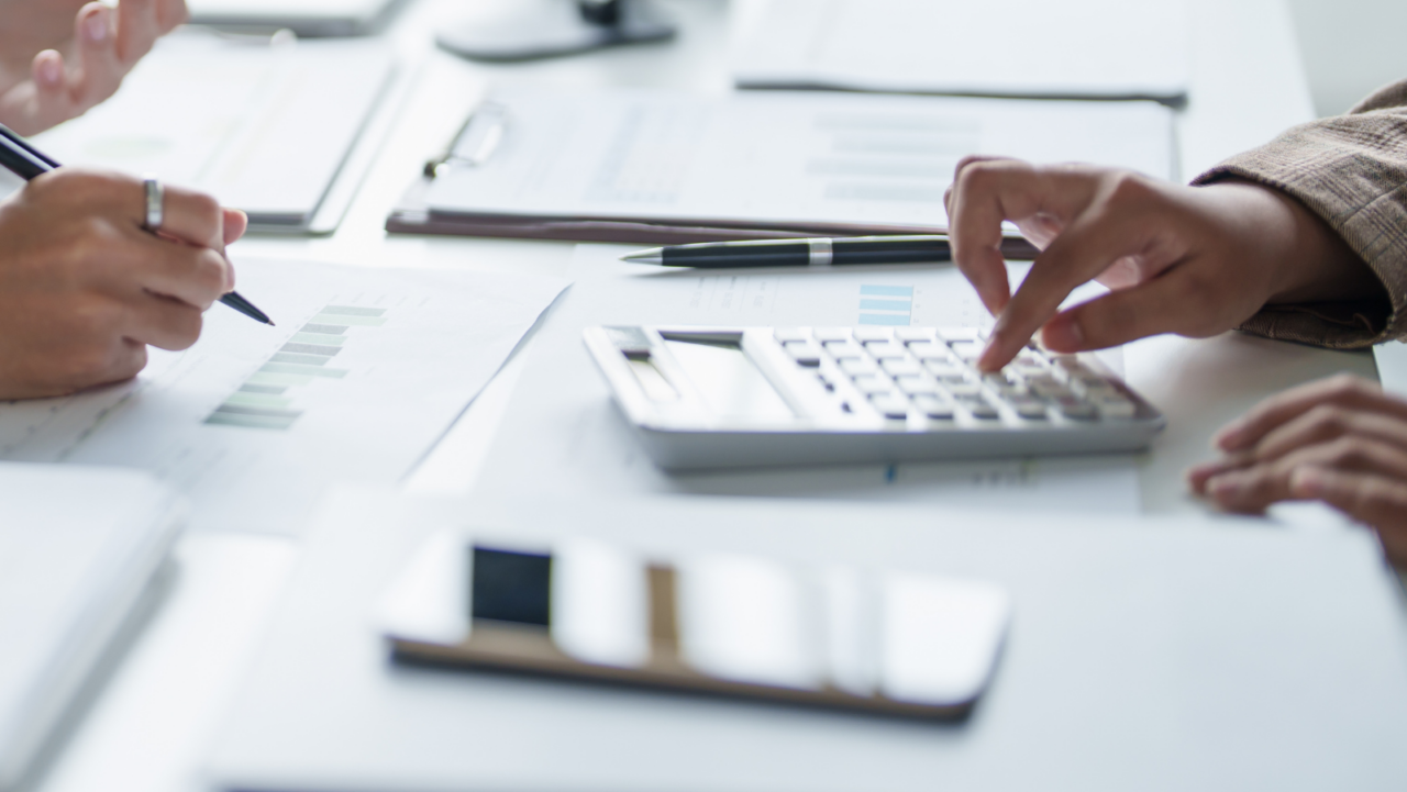 Financial services professionals reviewing documents and calculations during an operational support discussion.