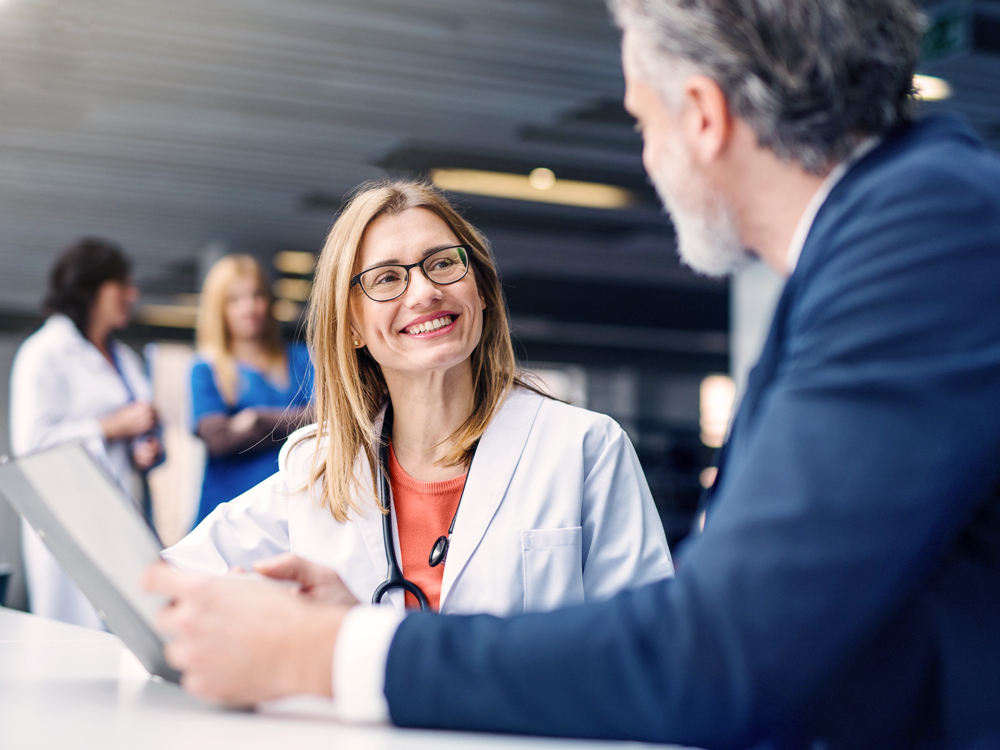 Smiling female doctor in discussion with a healthcare executive, representing life sciences staffing and executive recruitment