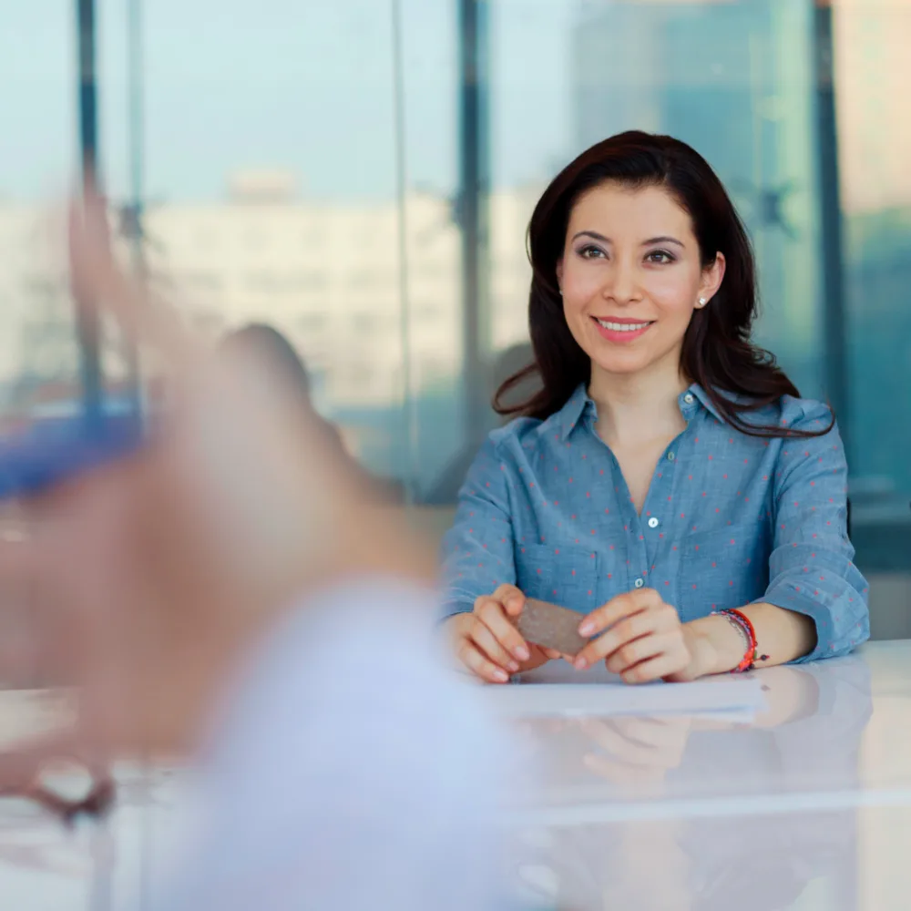 Smiling woman in a professional setting during a job interview, representing Beacon Hill’s commitment to personalized staffing solutions and career support.