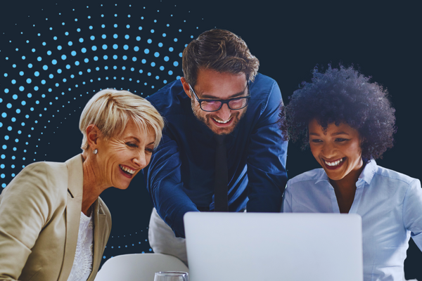A group of professionals gathered around a laptop reviewing business data in a modern office setting.